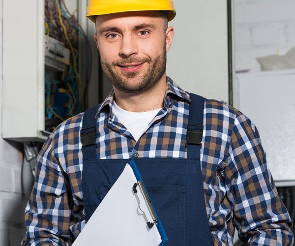 electrician-holding-clipboard-and-smiling-by-elect-JZP244K.jpg