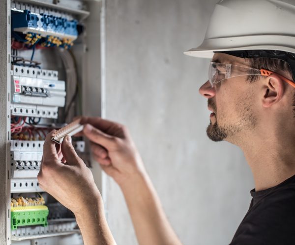 man-an-electrical-technician-working-in-a-switchboard-with-fuses-1-1.jpg