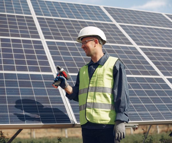 Engineer in a white helmet. Man near solar panel.